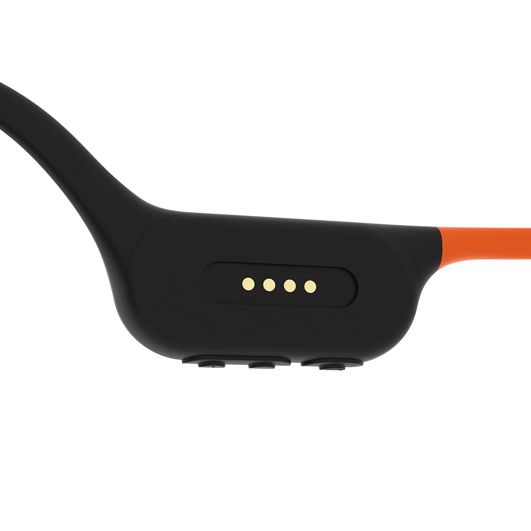 Sunset Orange GWS CURRENT 50 headphones, close-up of charging contacts and physical buttons
