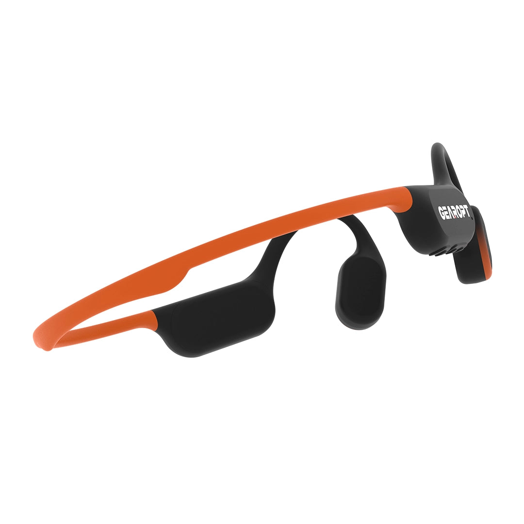 Sunset Orange GWS CURRENT 50 headphones, rear three-quarter view showing the flexible neckband